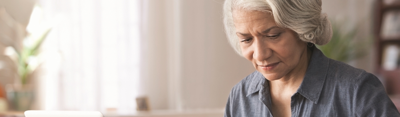 Woman looking at bills by laptop